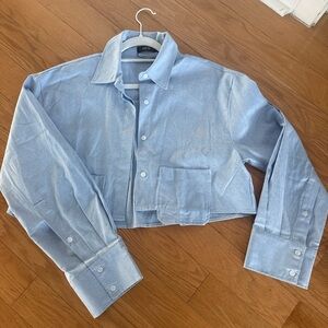 Cropped light blue button down shirt.